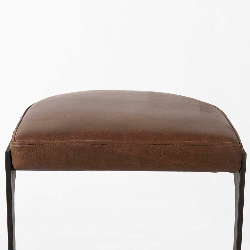 Black bar stool with iron base and U-shaped leather seat on a white background
