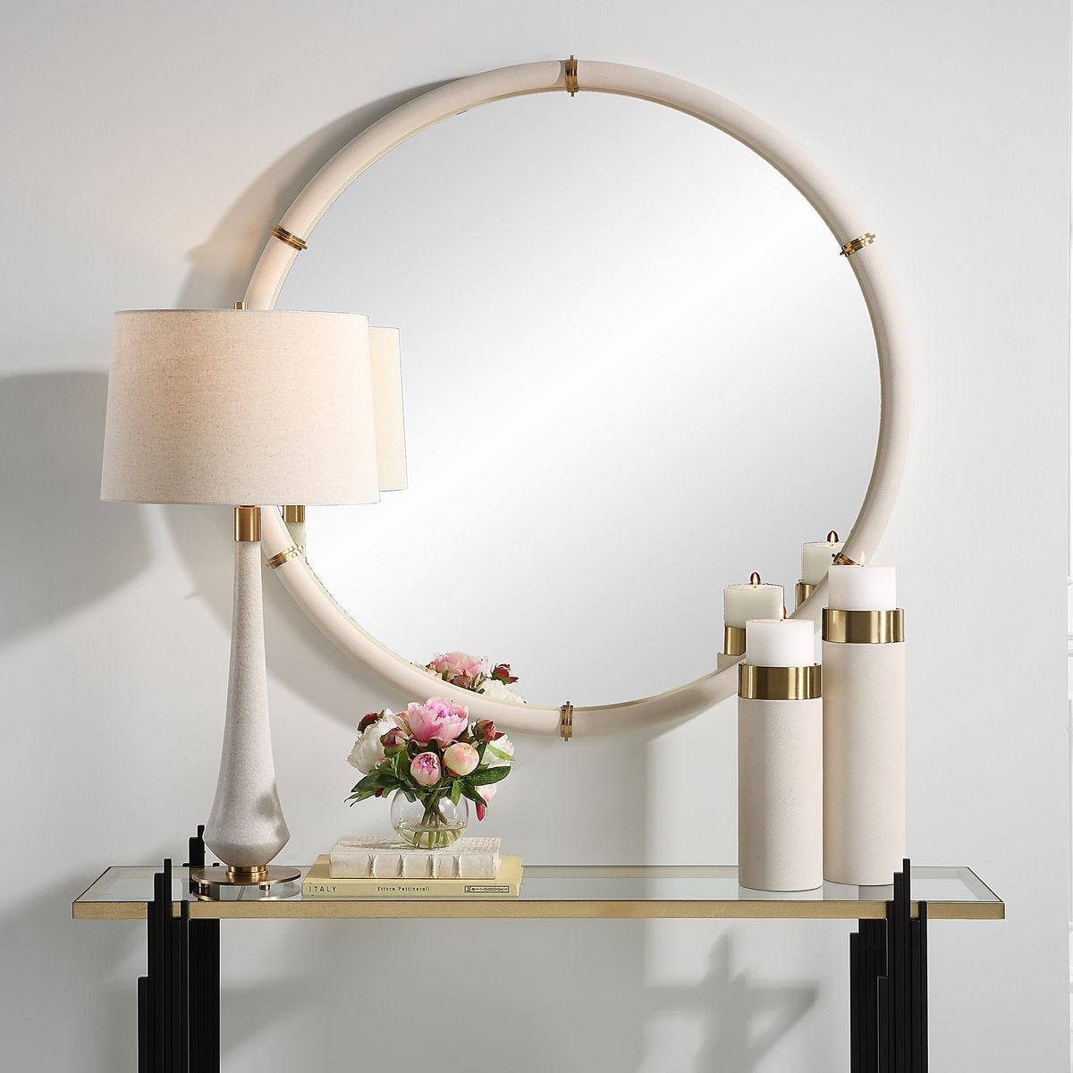 Cylen Round Accent Mirror on a white wall above a table at Addison West