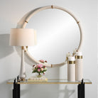 Cylen Round Accent Mirror on a white wall above a table at Addison West