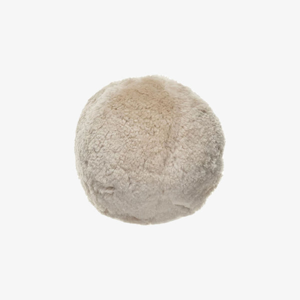 Round sheepskin orb pillow on a white background