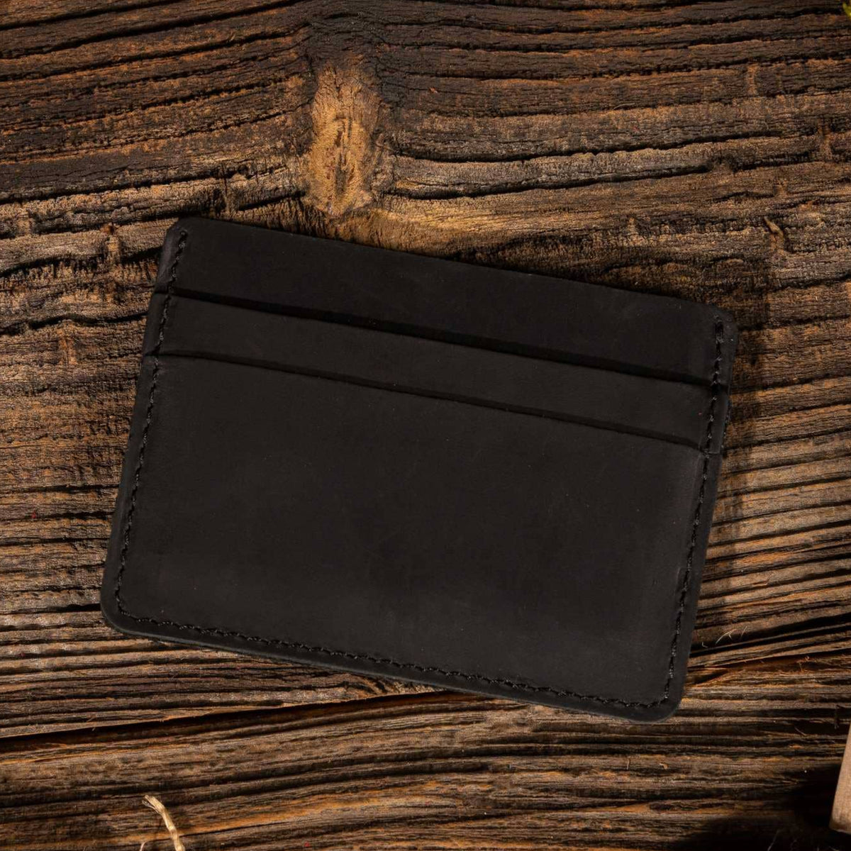 Leather Card Holder Wallet in Black on a table at Addison West