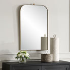 Caswell Arch Accent Mirror on a white wall above a table at Addison West