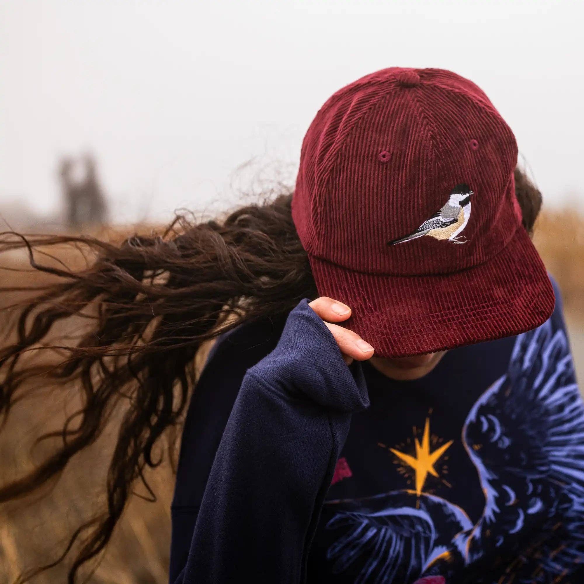 Chickadee Corduroy Hat in Merlot on a model outside at Addison West