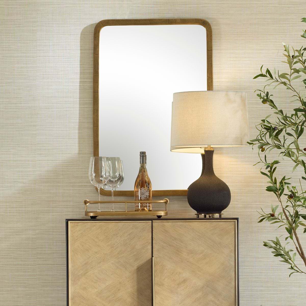 Vesden Accent Mirror on a beige wall above a table at Addison West