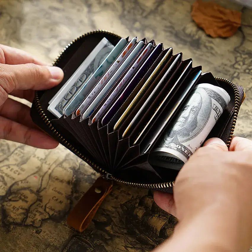 Zippered Small Leather Wallet in Dark Brown on a table at Addison West