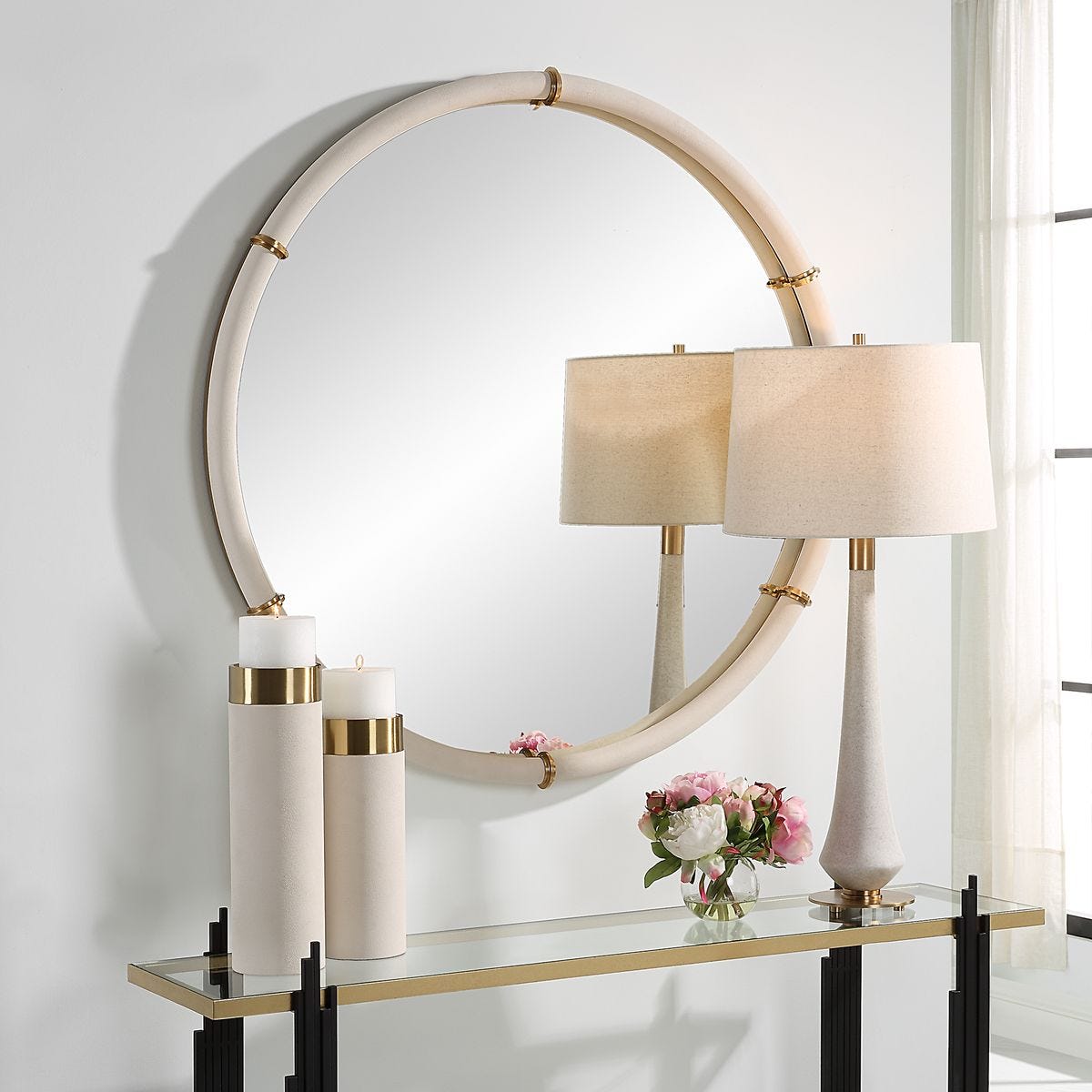 Cylen Round Accent Mirror on a white wall above a table at Addison West