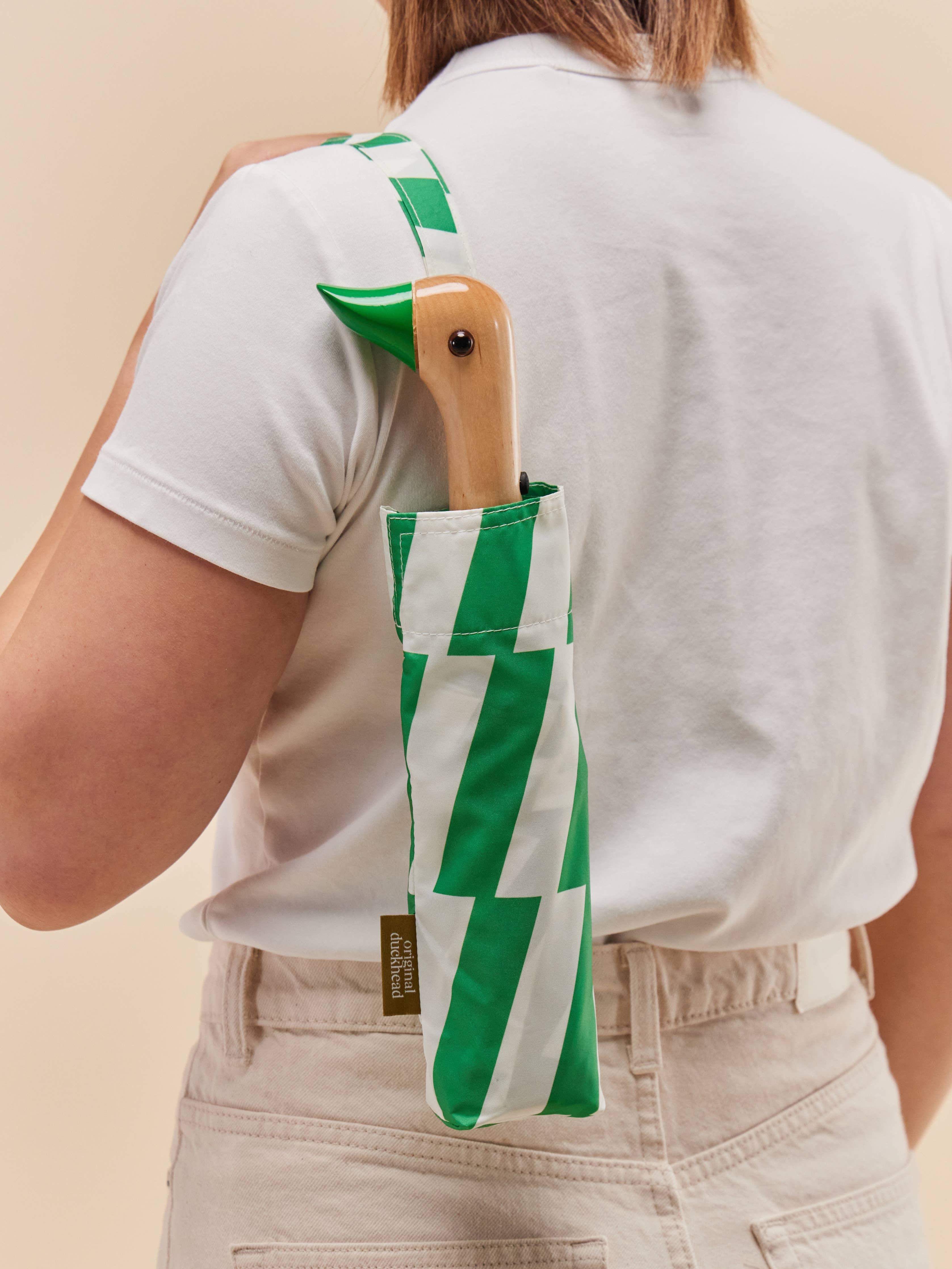 Person holding Original Duckhead Kelly Bars Eco-Friendly Umbrella on a beige background at Addison West