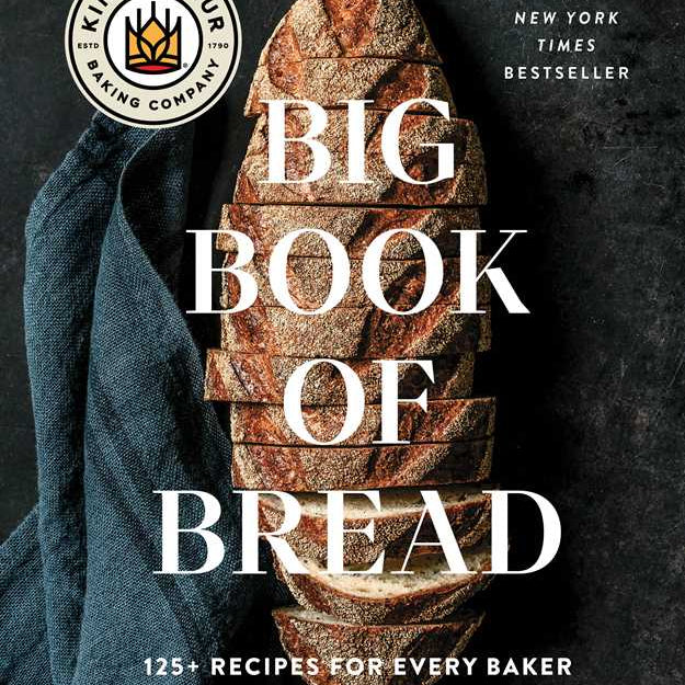 Book cover of 'Big Book of Bread' by King Arthur Baking Company with a loaf of bread and blue towel on a dark background.