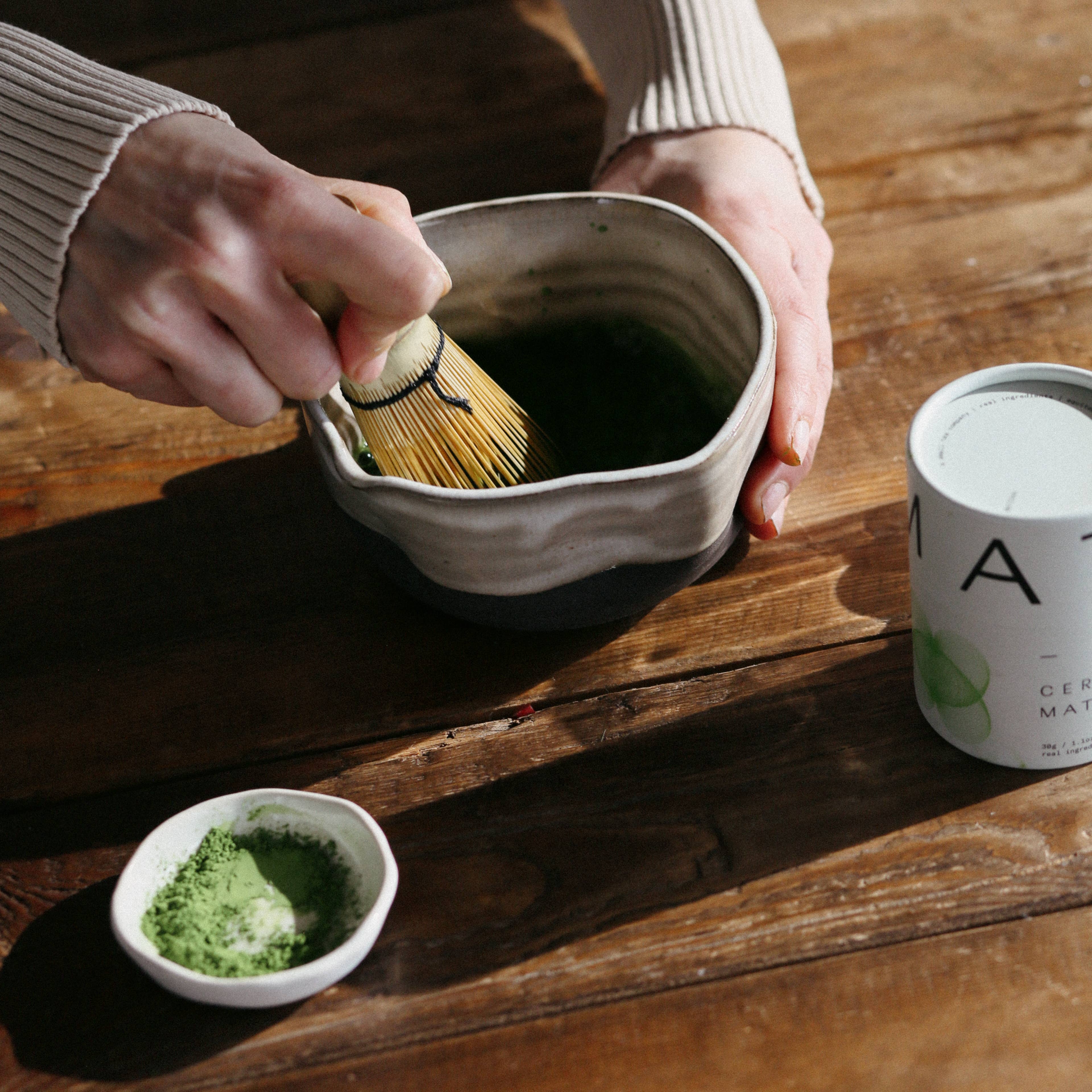 Person whisking matcha on a table at Addison West