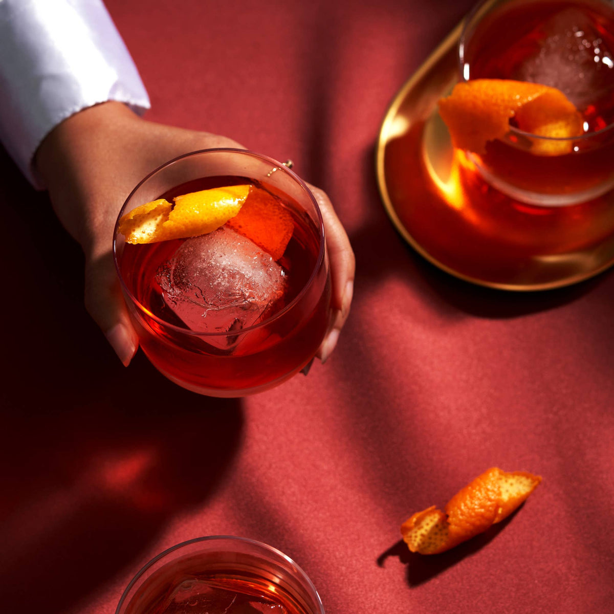 Raye™ Crystal Lowball Negroni Glasses on red table at Addison West