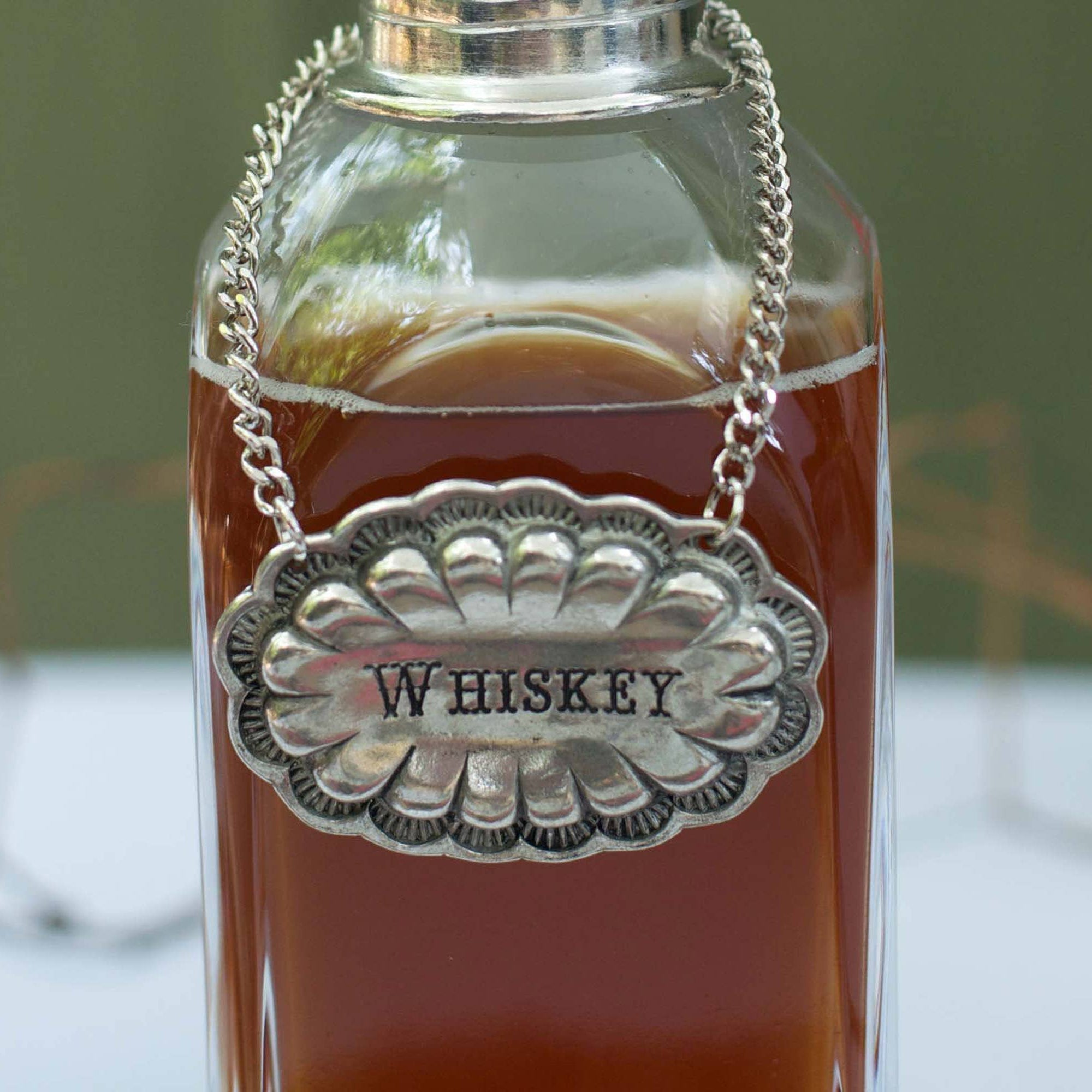 Whiskey Pewter Western Decanter Tag on a bottle at Addison West