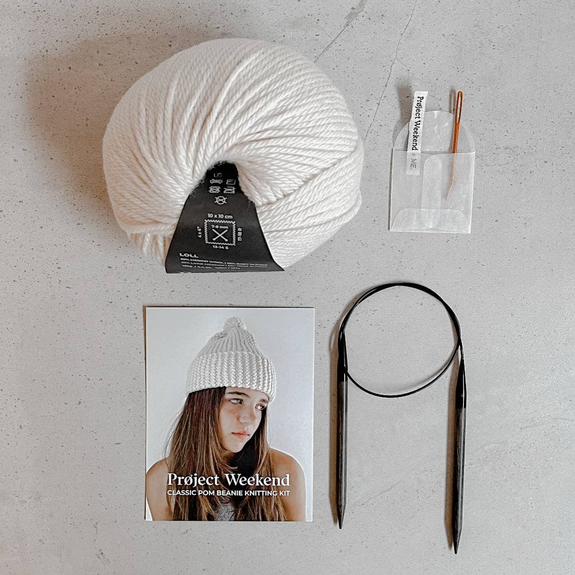 Knitting Craft Kit: Classic Pom Beanie in Sand on a beige background at Addison West