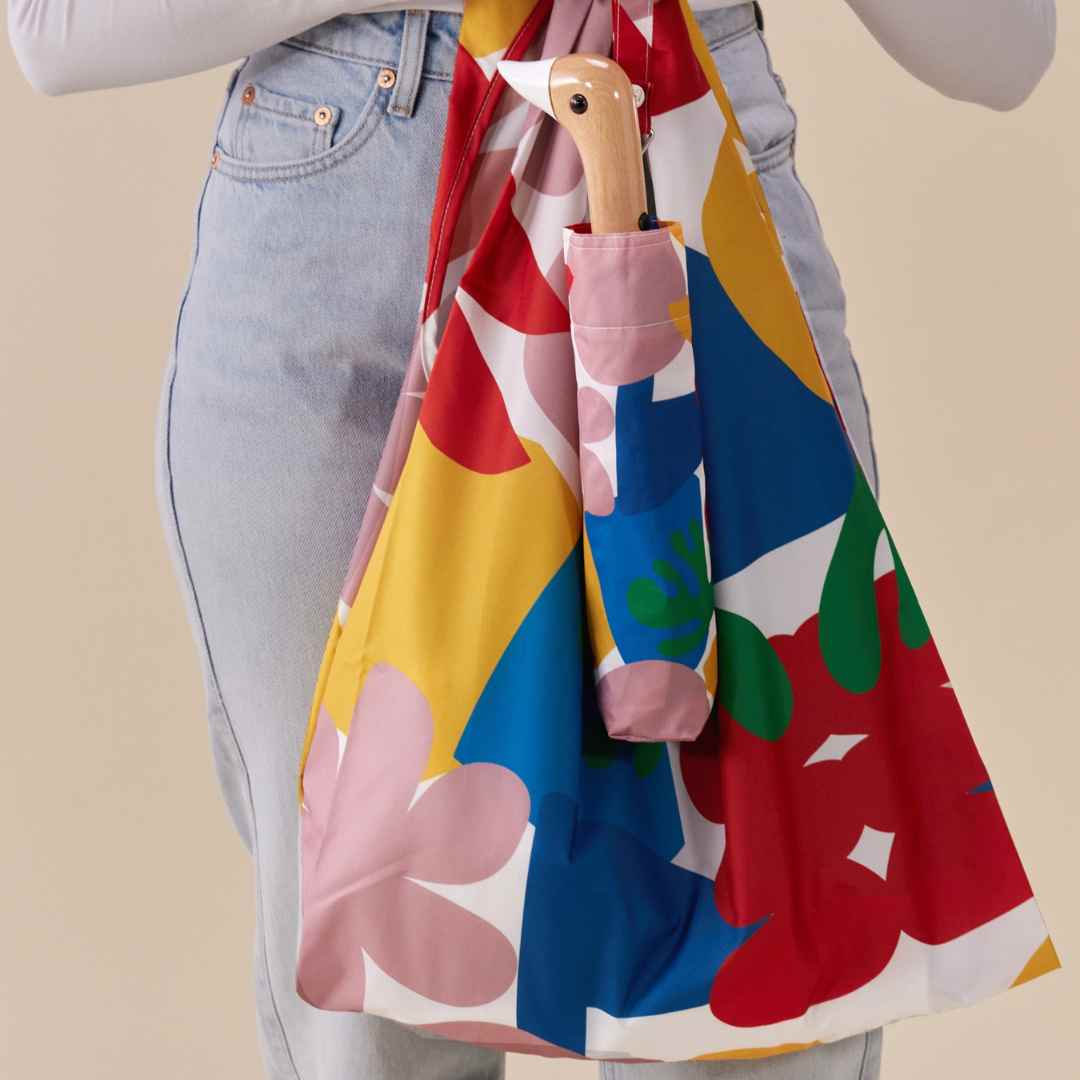 Person holding Original Duckhead Matisse Eco-Friendly Umbrella on a beige background at Addison West