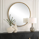 Sutcliffe Round Accent Mirror on a white wall above a table at Addison West