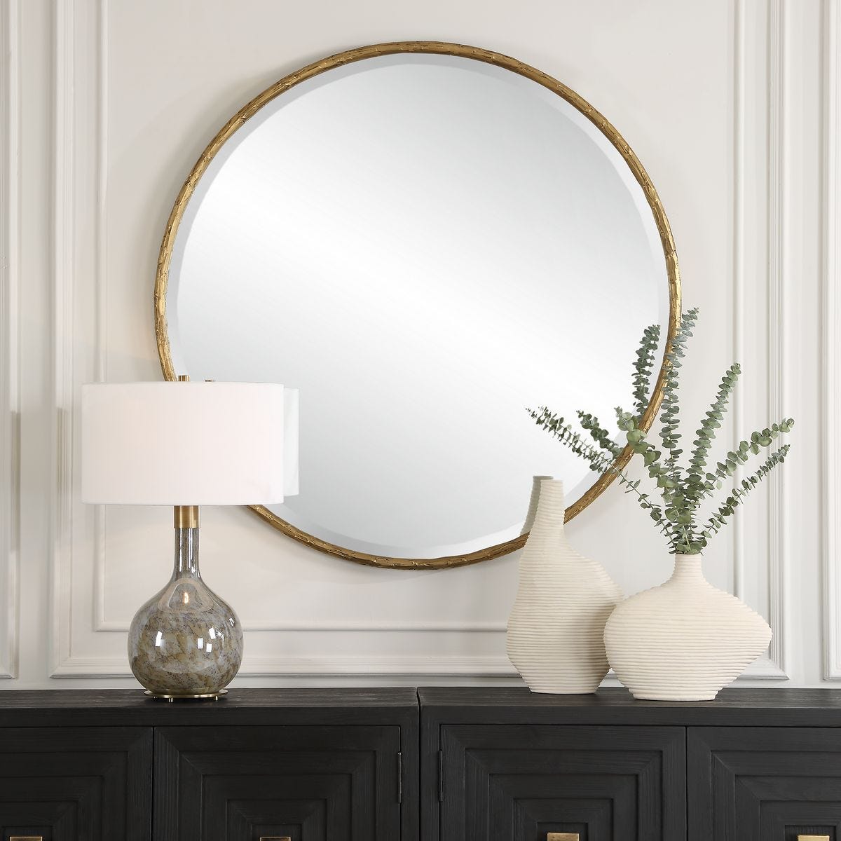 Sutcliffe Round Accent Mirror on a white wall above a table at Addison West