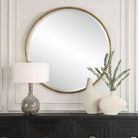 Sutcliffe Round Accent Mirror on a white wall above a table at Addison West