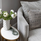 Close up of Four hands brand Farrah chaise with small marble side table and flowers