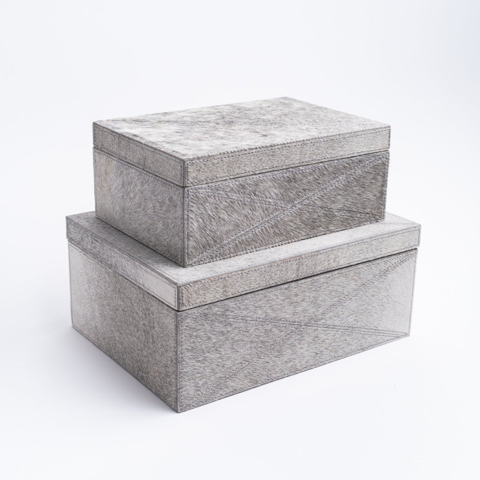 Two sizes of cowhide storage boxes stacked on a white background from Addison West home goods