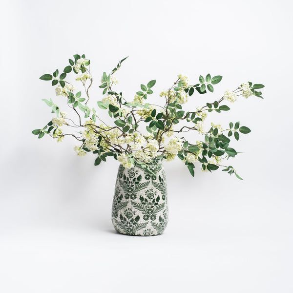 White vase with green floral transfer ware pattern on a white background