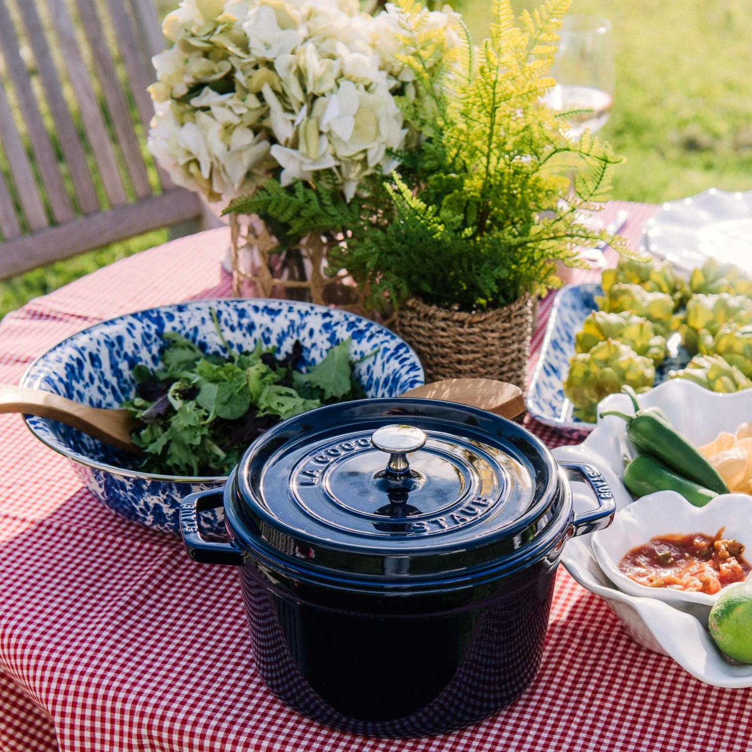 Golden Rabbit brand blue and white Cobalt Swirl Enamelware round serving bowl on an outdoor table with salad in it