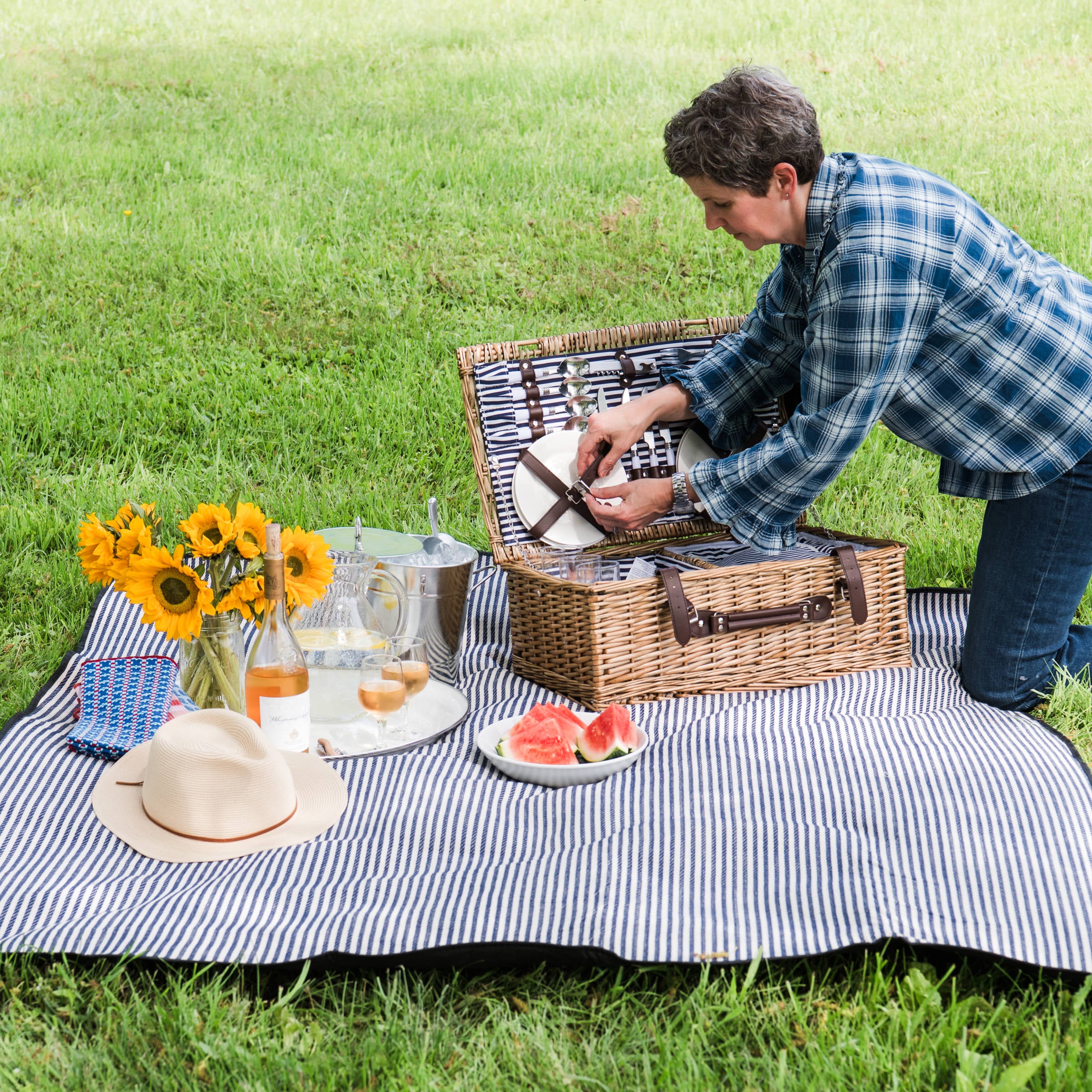 Covington Classic Willow Four Person Picnic Basket on a picnic blanket with a model at Addison West