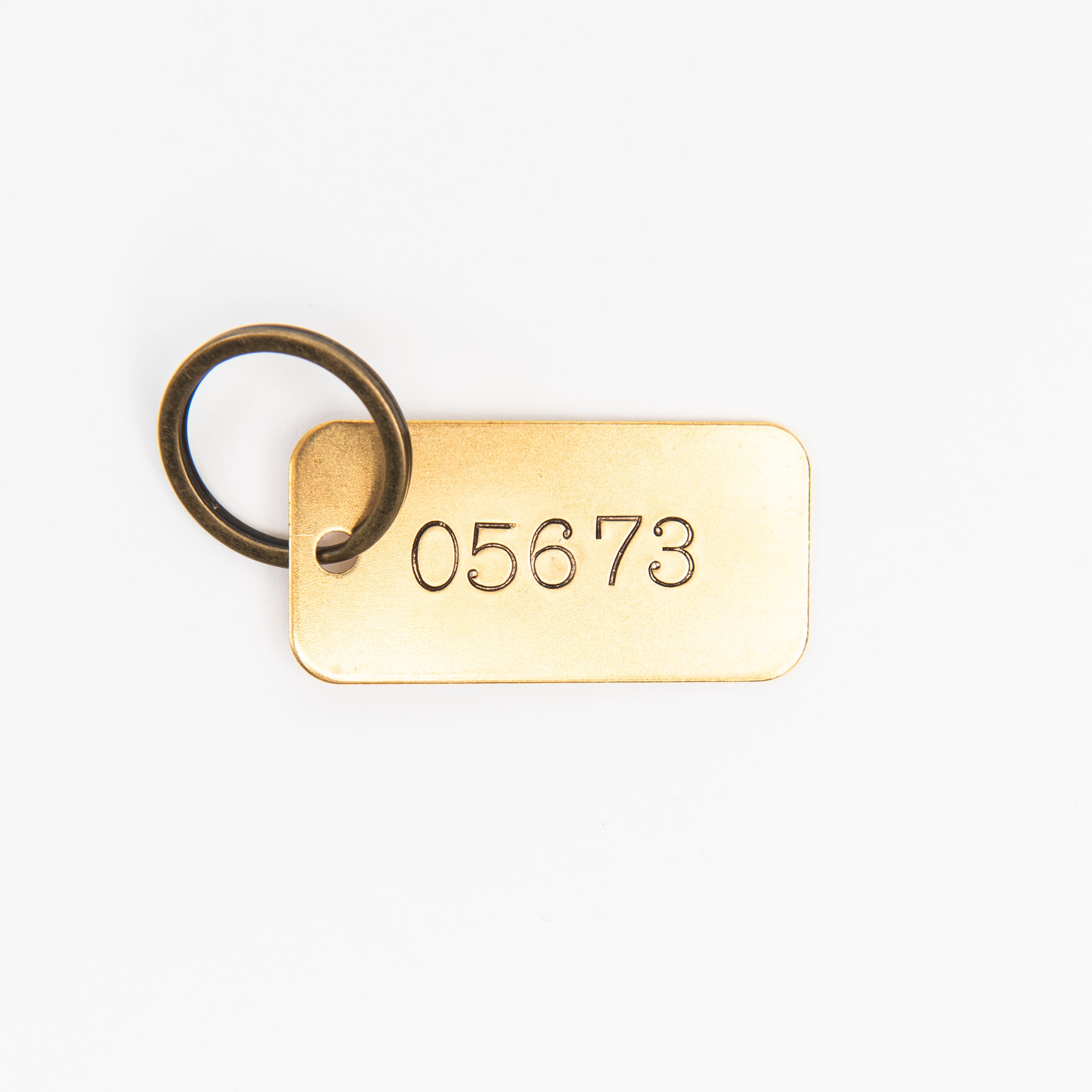 05673 Rectangular Brass Key Ring on a white background at Addison West