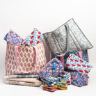 Collection of block printed bags, cosmetic bags, napkins, and table cloths on a white background at Addison West