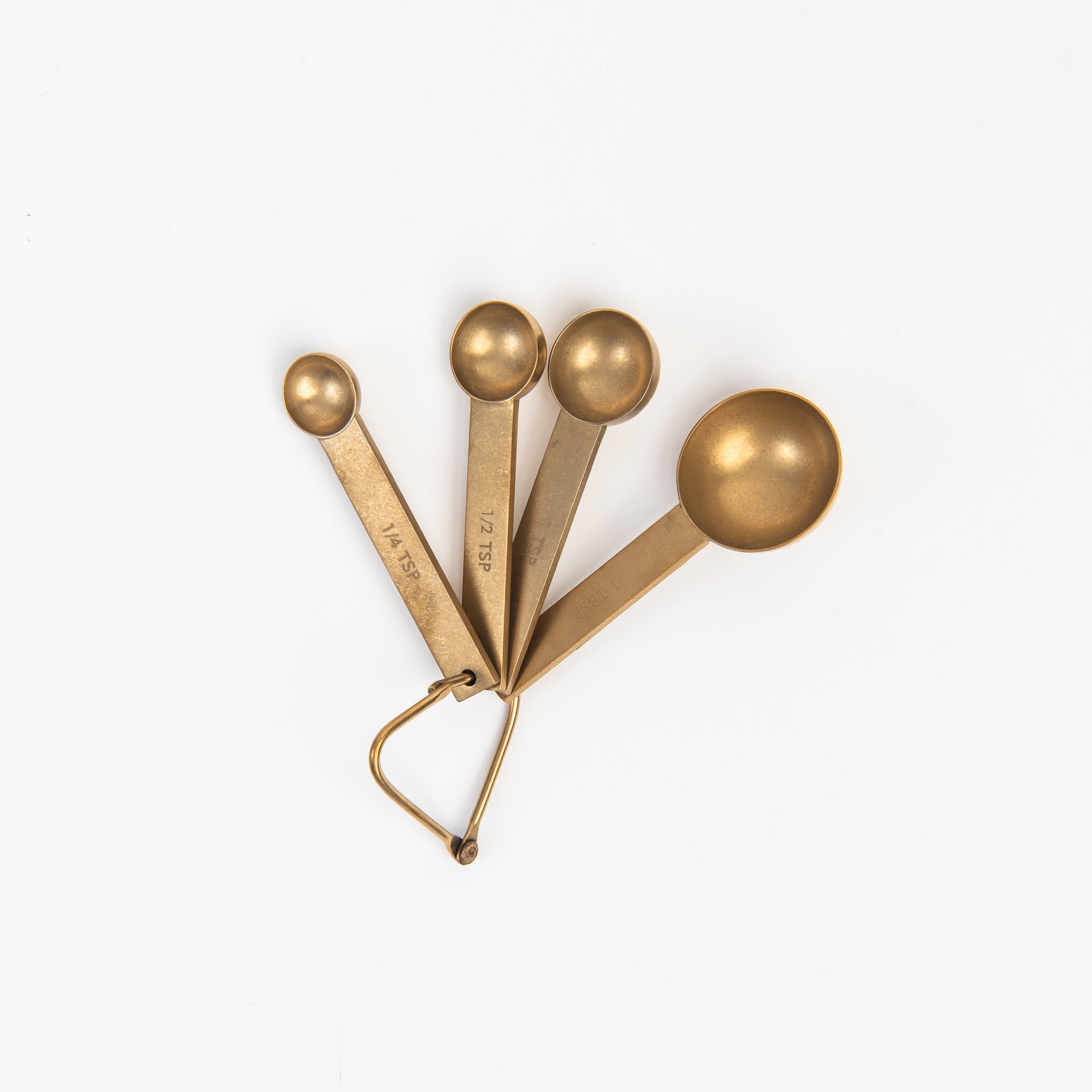 Cultivar Measuring Spoons in Tumbled Gold on a white background at Addison West