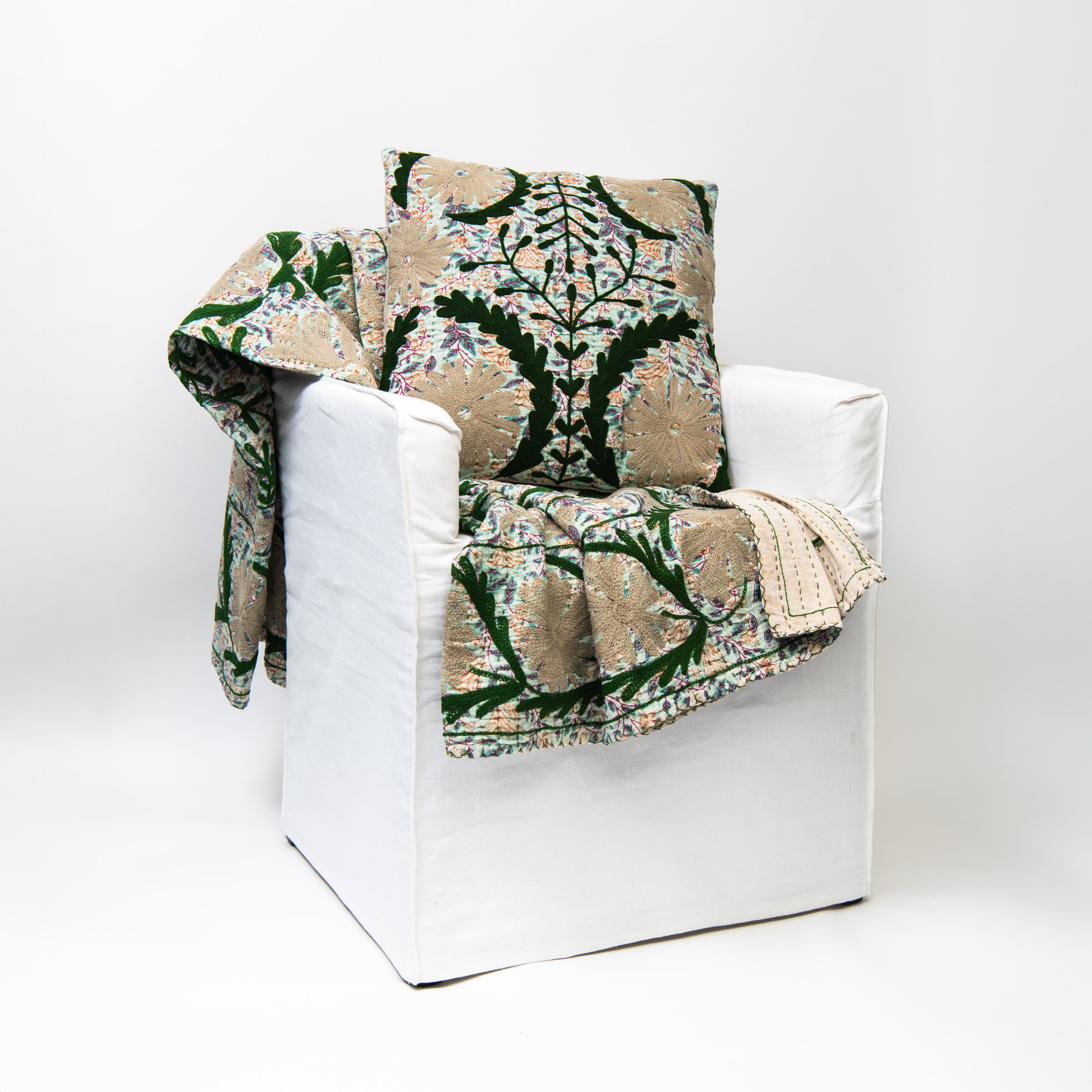 Voile 18" Printed Throw Pillow and throw blanket on a white chair on a white background at Addison West
