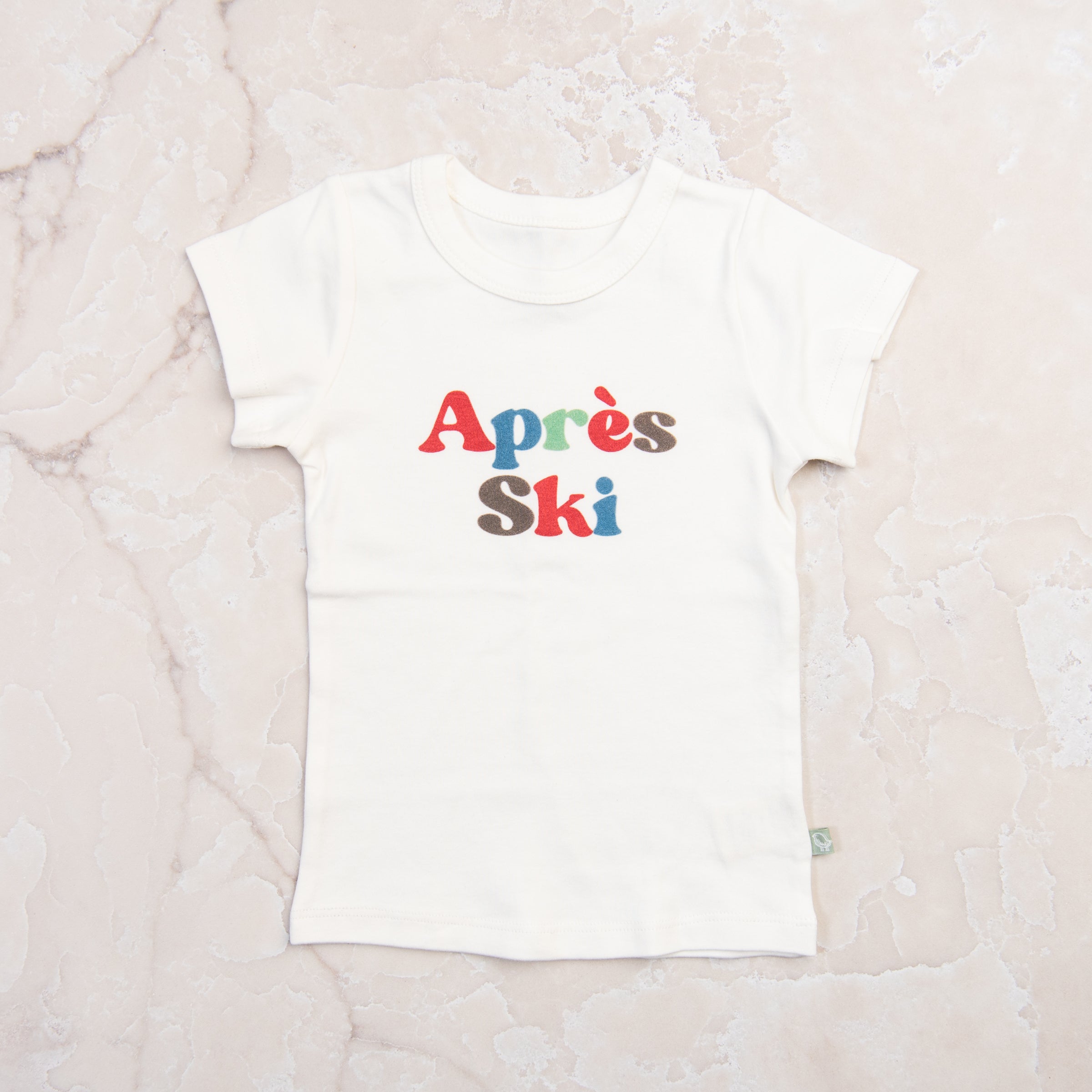 Kid Toddler Graphic Tee in Apres Ski on a marble table at Addison West