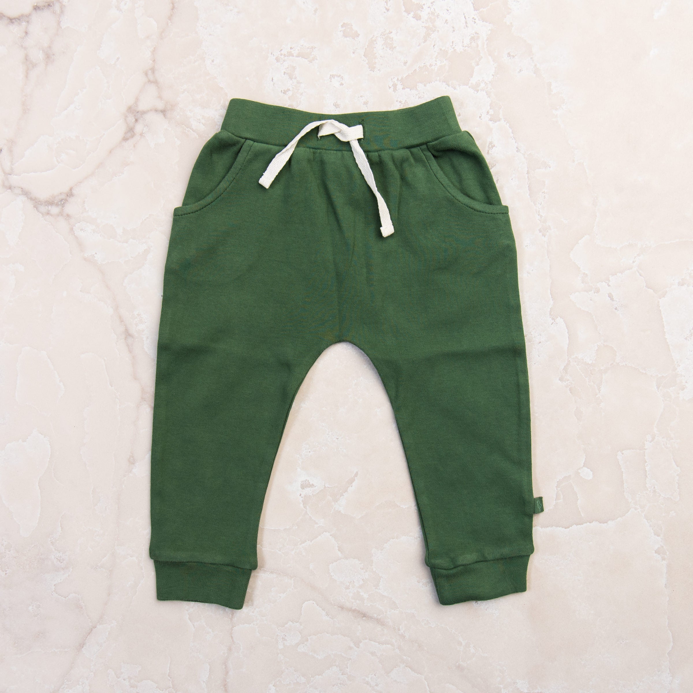 Organic Lounge Pants in Basil Green on a marble table at Addison West