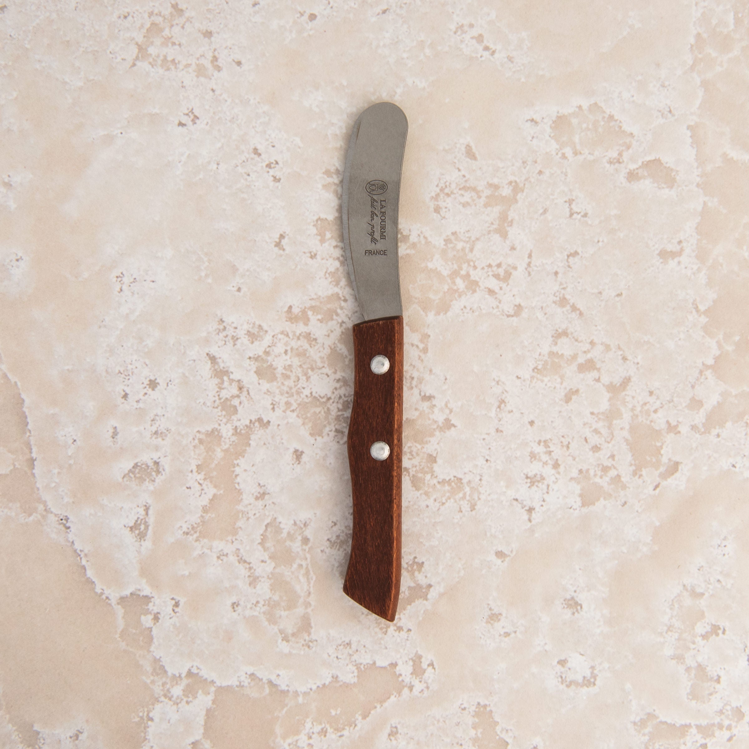 La Fourmi Butter Knife on a beige background at Addison West