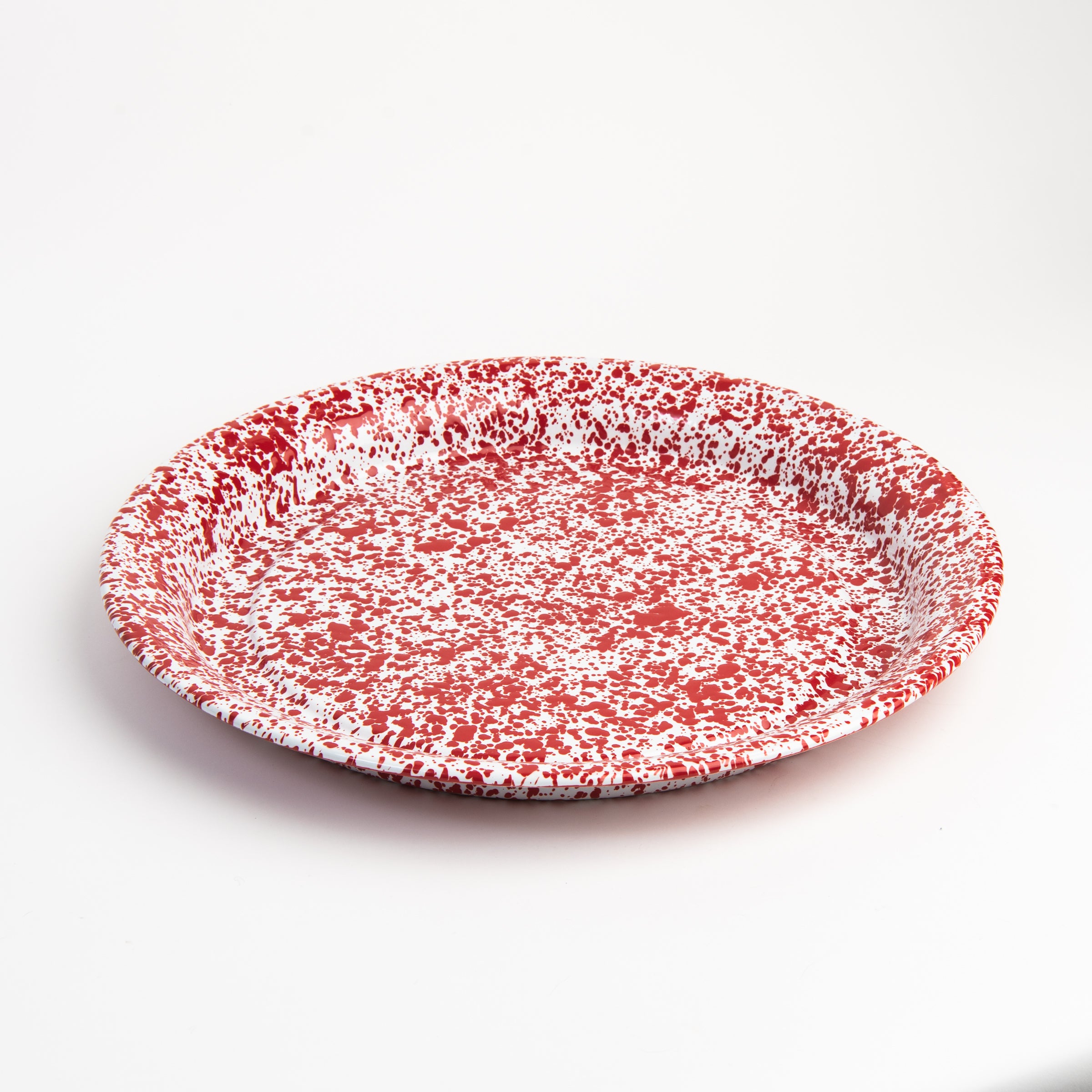 Large round enamelware red serving tray on a white background