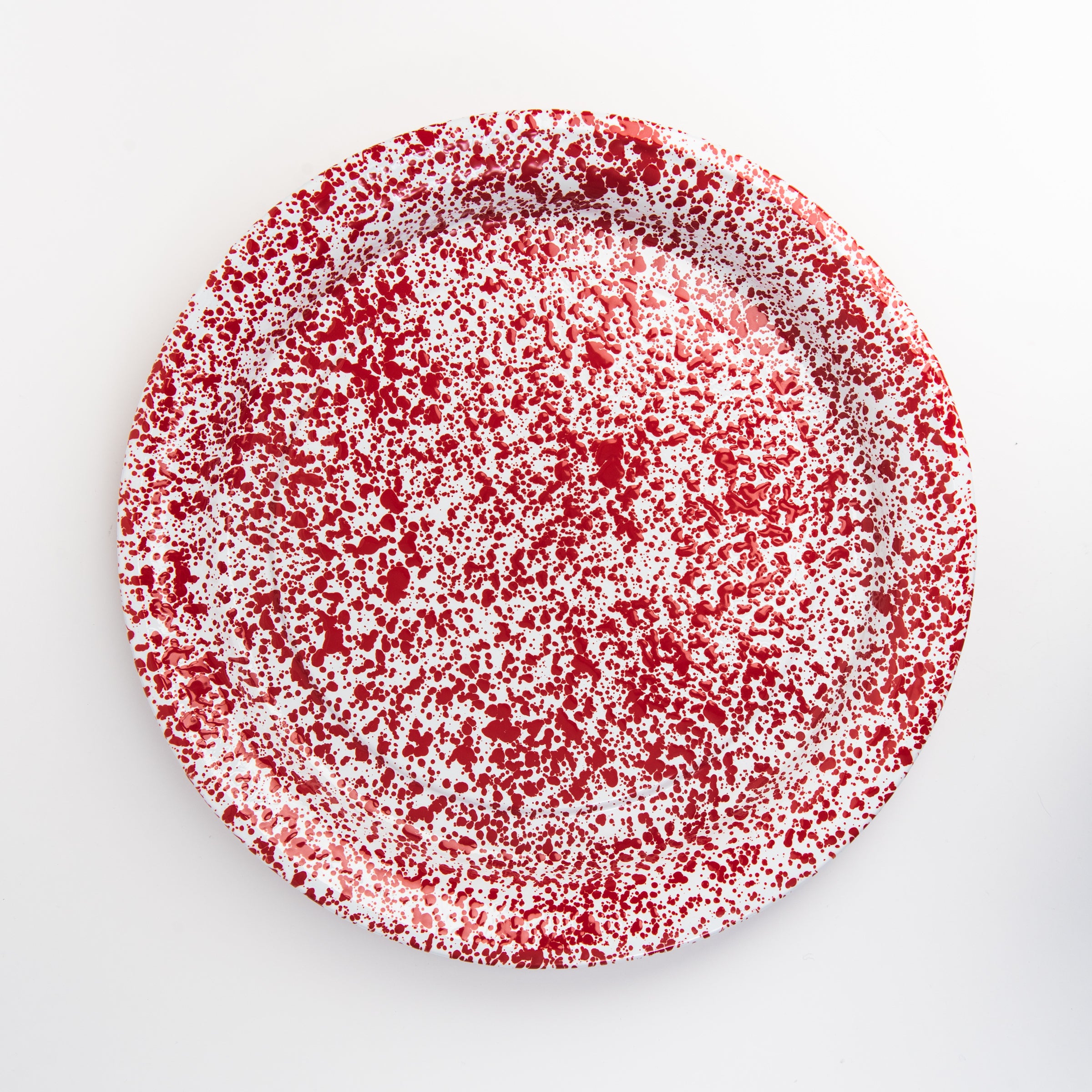 Large round enamelware red serving tray on a white background