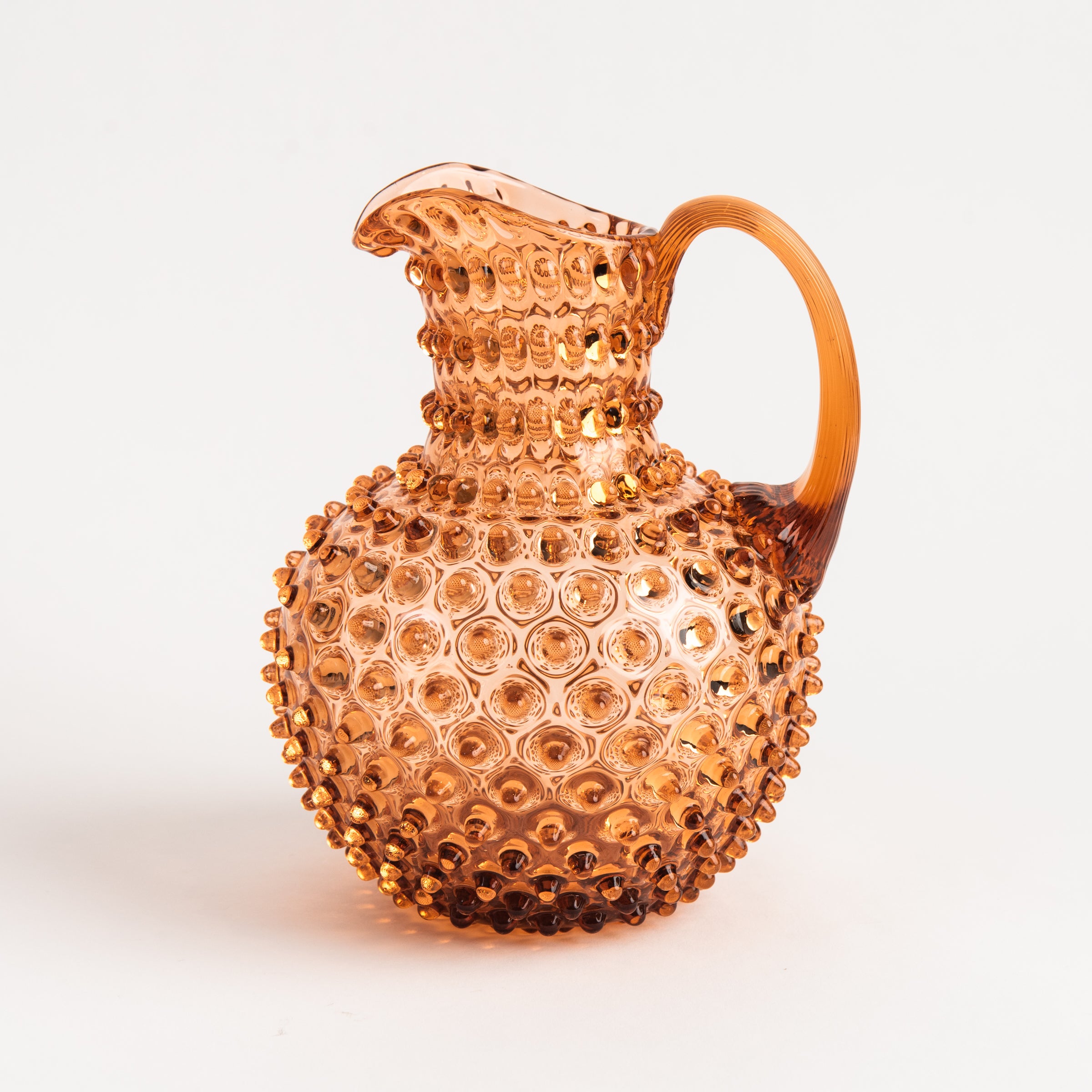 Hobnail Glass Pitcher in Honey Gold on a white background at Addison West