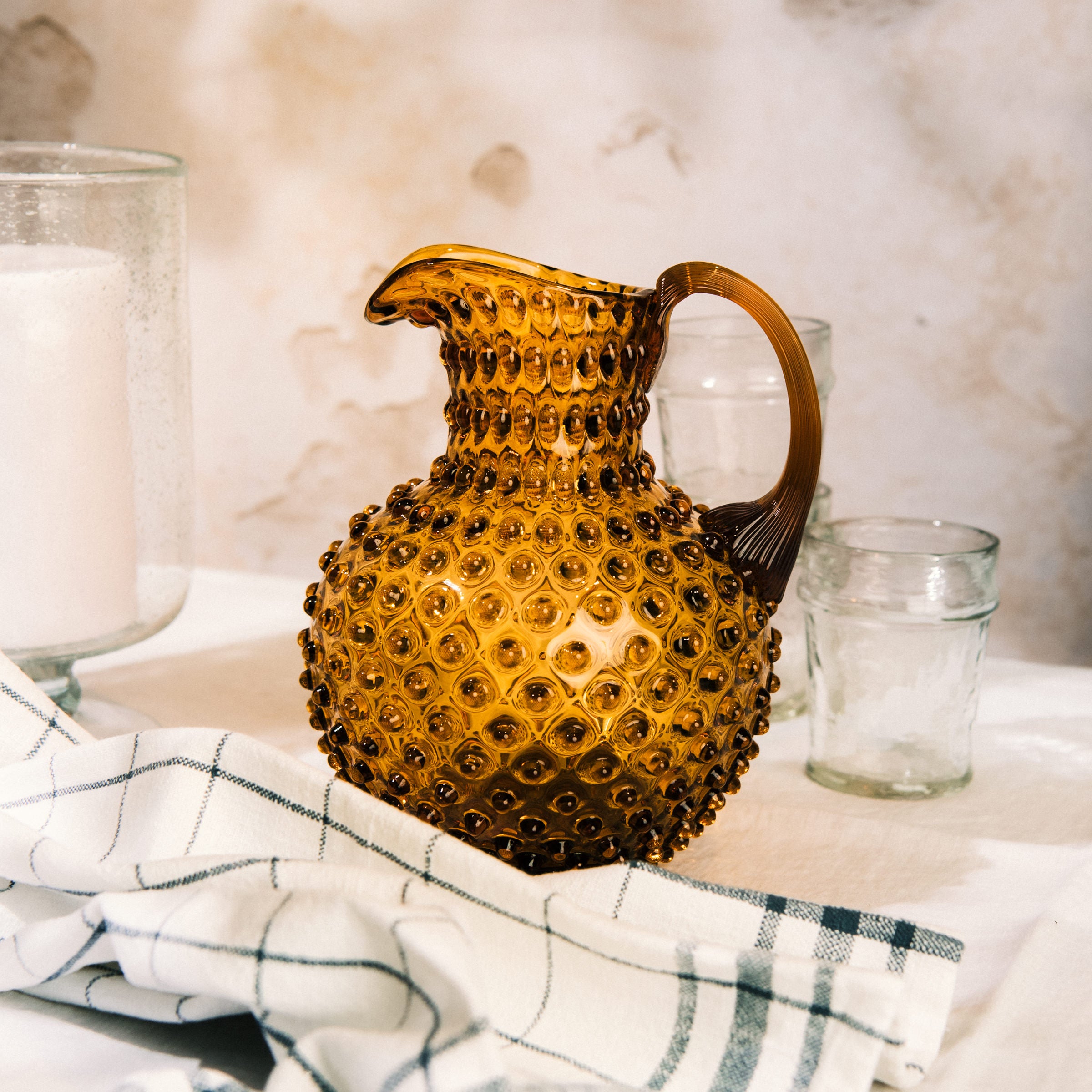 Hobnail Glass Pitcher in Saffron Light on a table at Addison West