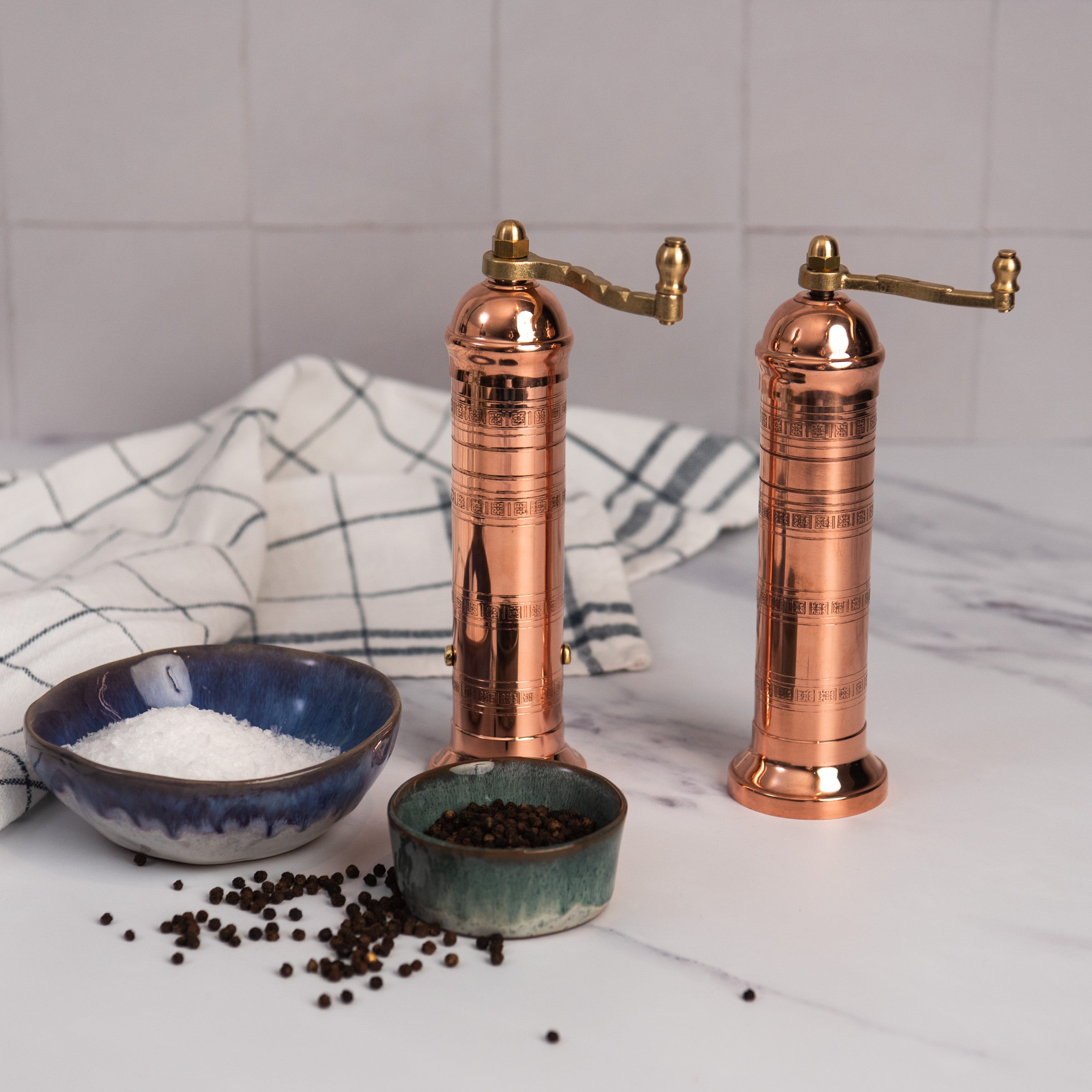 Alexander 8" Copper Salt Mill and pepper mill on a white kitchen counter at Addison West