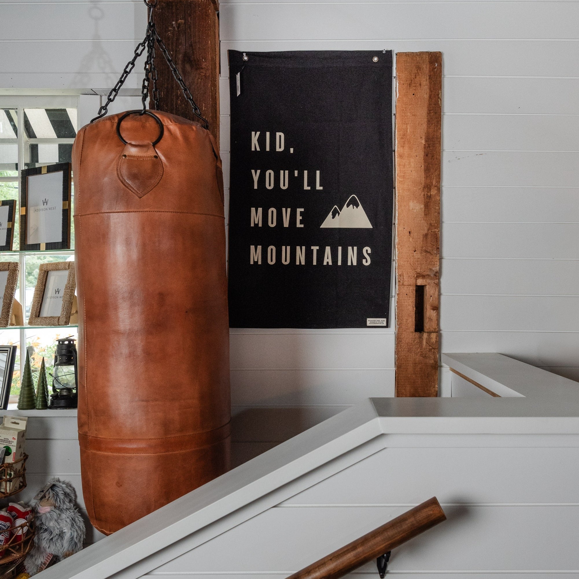 Pugilist Bag vintage punching bag in a room with ship lap walls