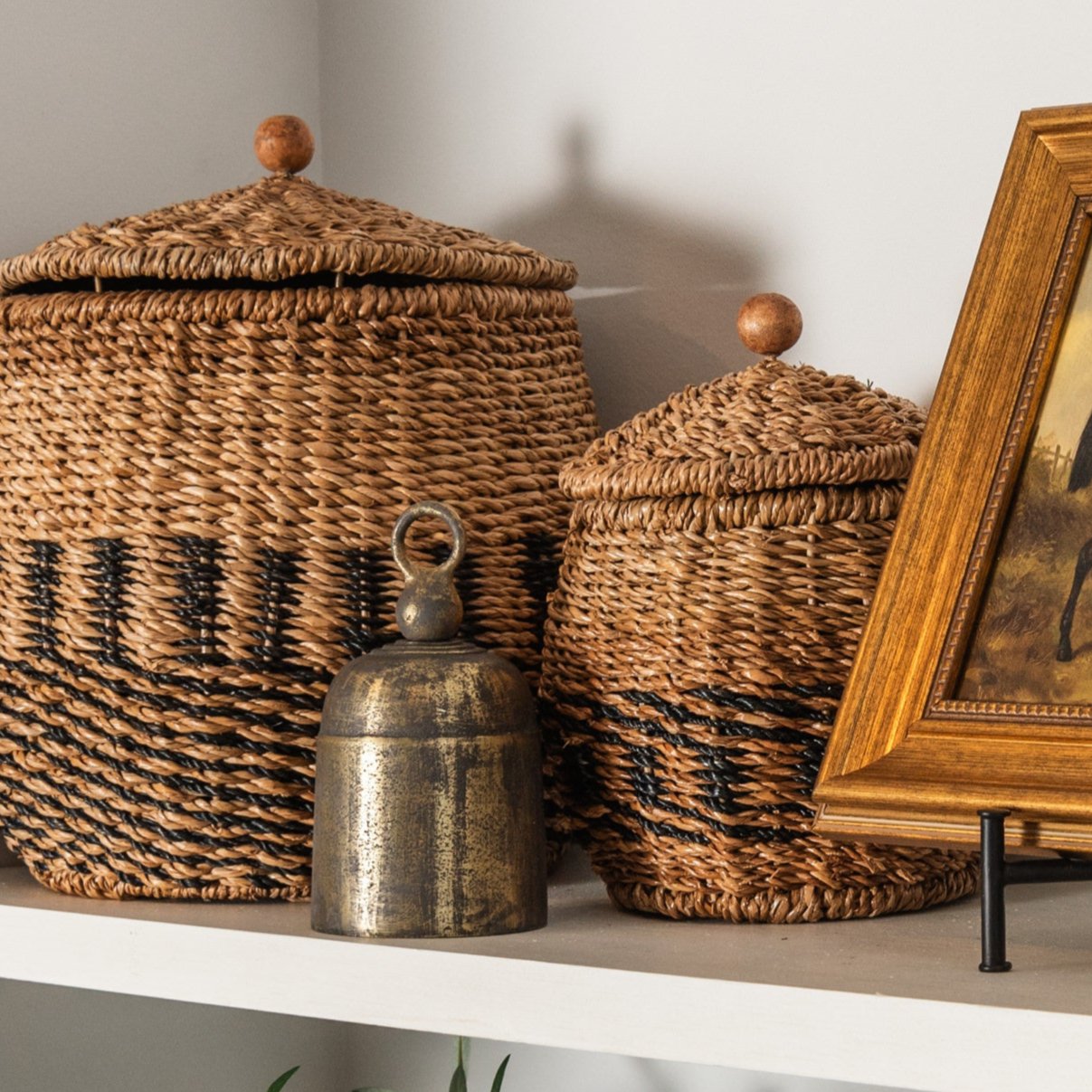 La Taverna Bells on a shelf with a painting and baskets