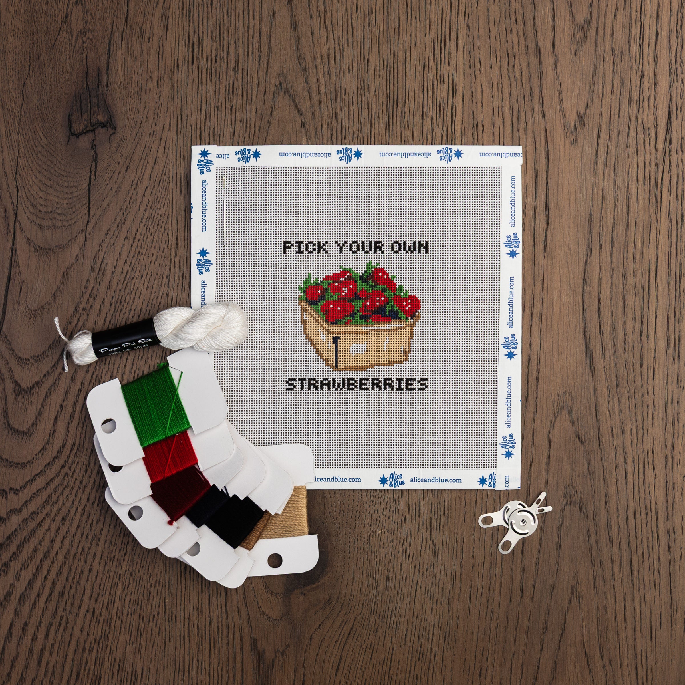 Pick Your Own Strawberries Needle Point Kit on a wood table at Addison West