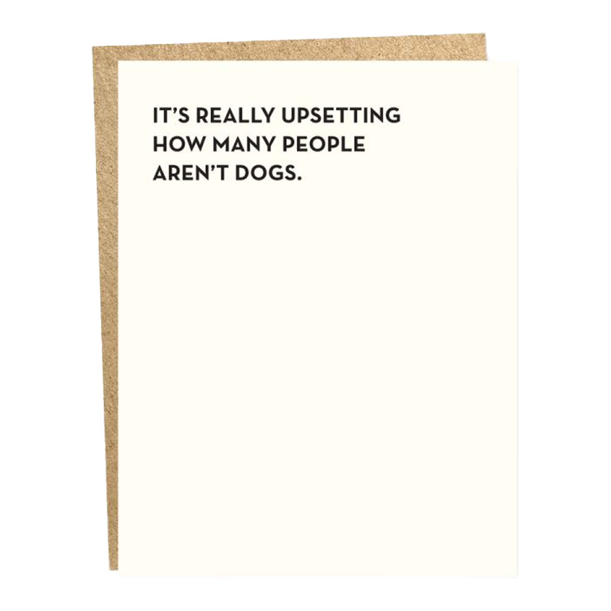 Greeting card with the text 'IT'S REALLY UPSETTING HOW MANY PEOPLE AREN'T DOGS.' written in black on a white background, with a brown envelope.
