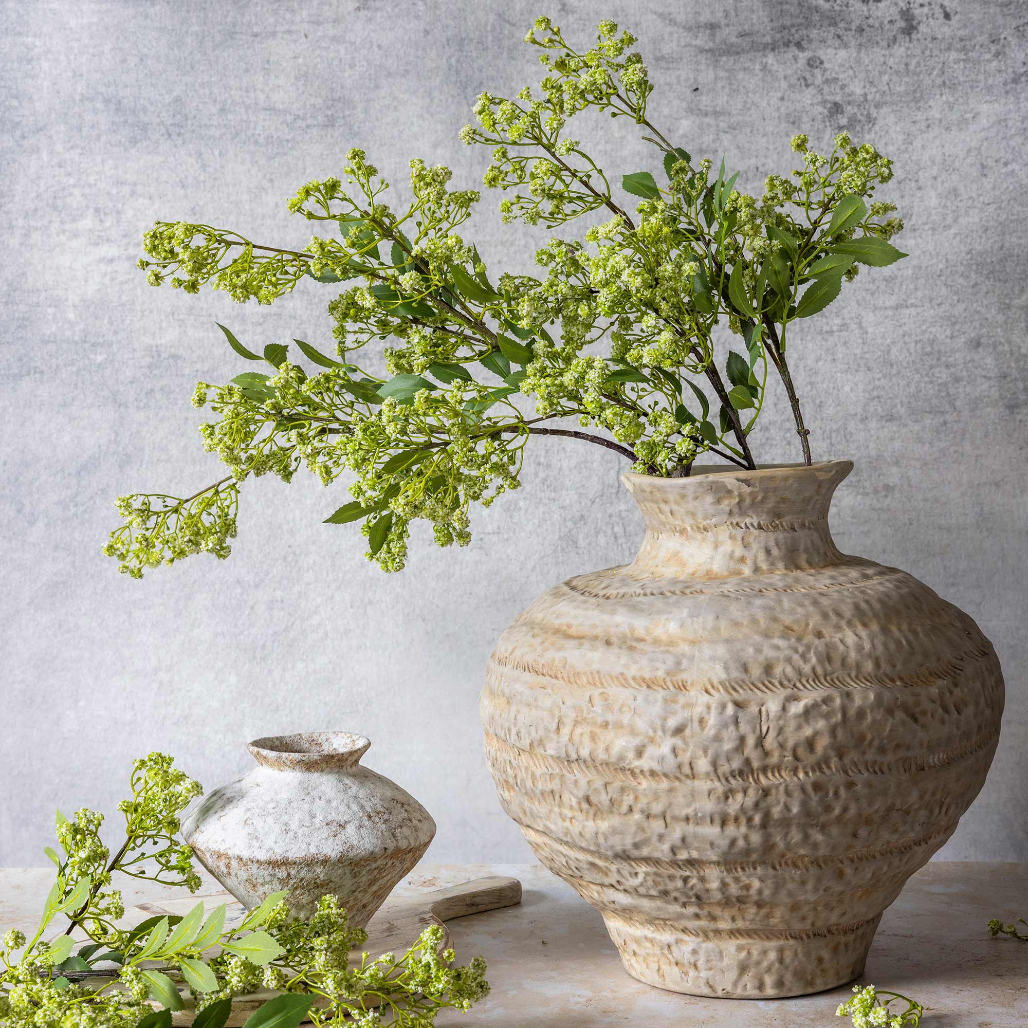 Abigail Ahern Faux Summer Garden Branch in a vase on a grey background at Addison West