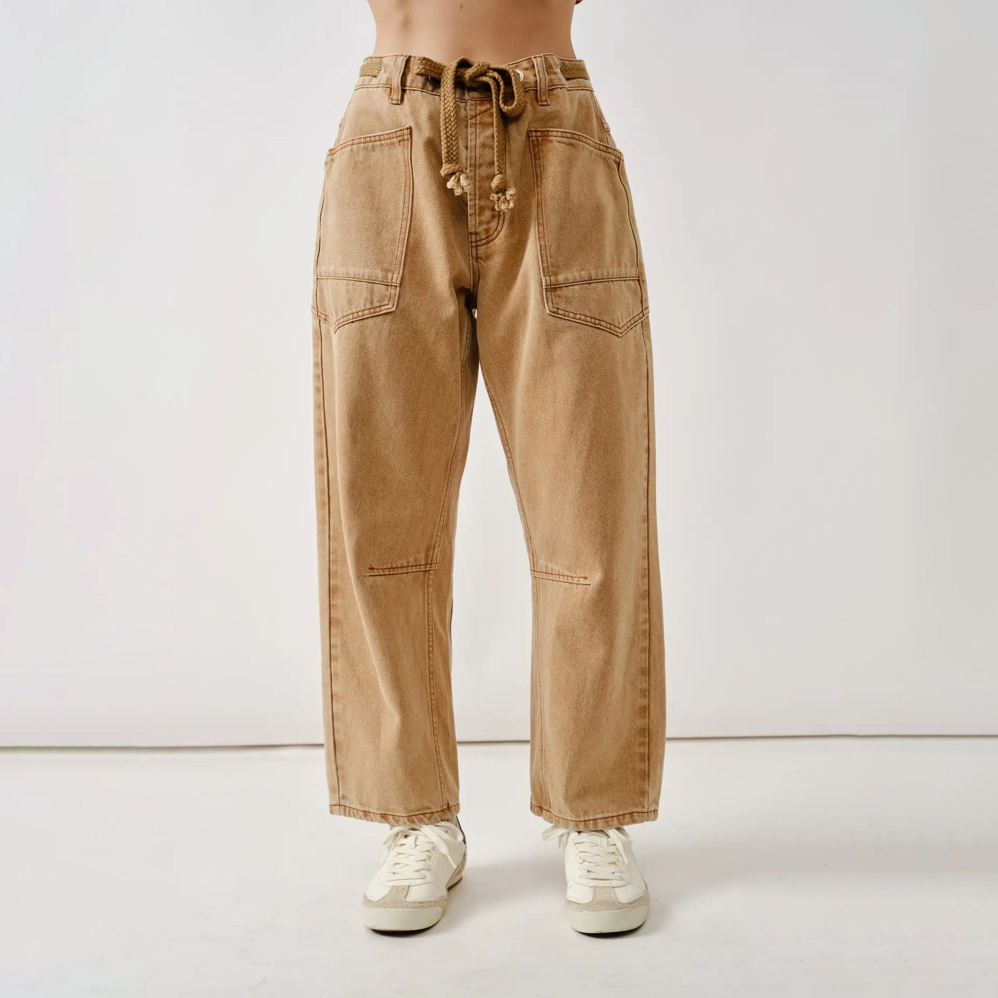 Aaron and Amber Tan barrel jeans worn by a person on a white background