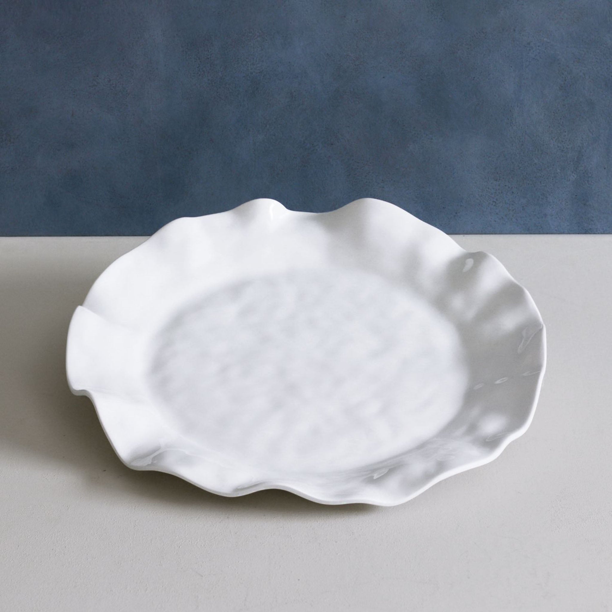 Beatriz Ball Melamine Havana Round Platter on a grey counter surface