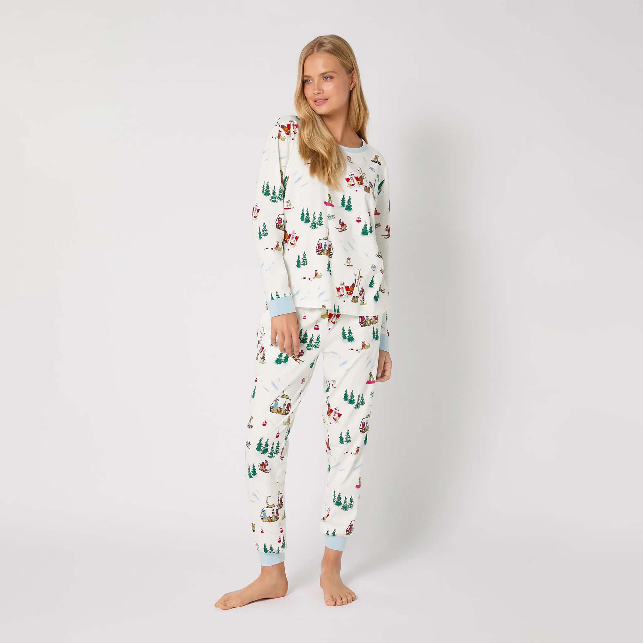 Woman wearing a festive pajama set with a white background