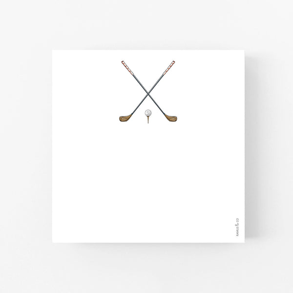 Square notepad with two golf clubs and ball and tee on a white background