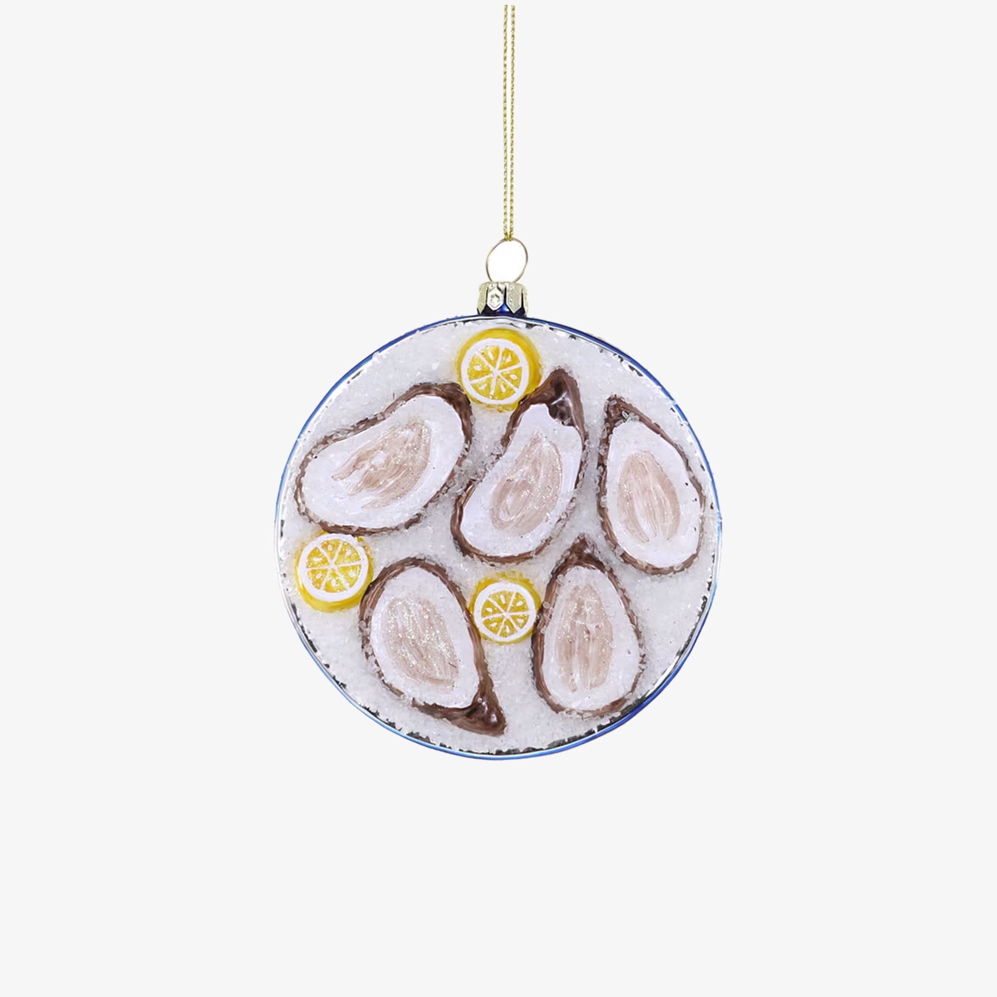 A round ornament featuring a plated dish with animated oysters on ice, garnished with lemon slices, and a blue and white patterned rim.