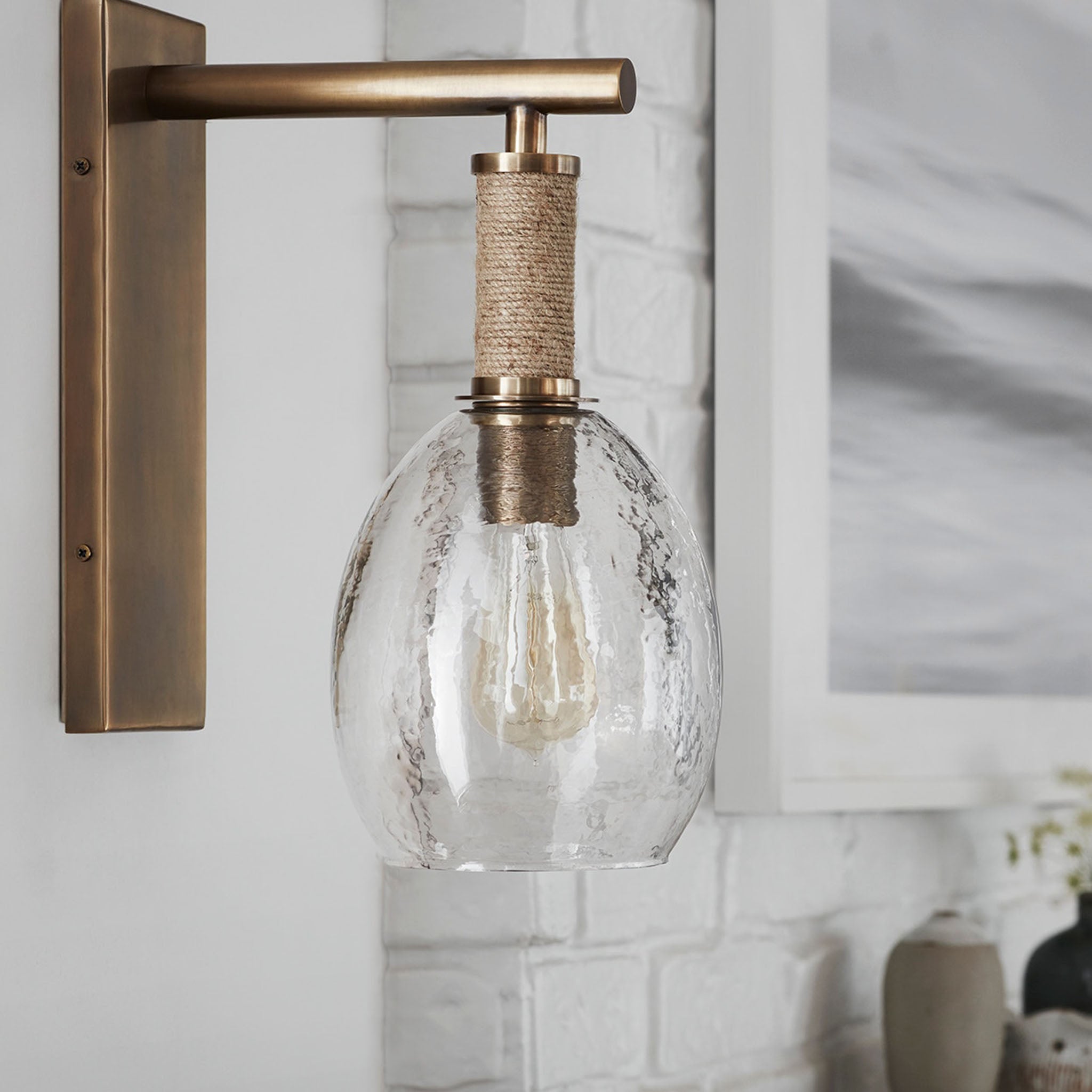 Kirk Nix Bronson Sconce In Brass on a white wall at Addison West