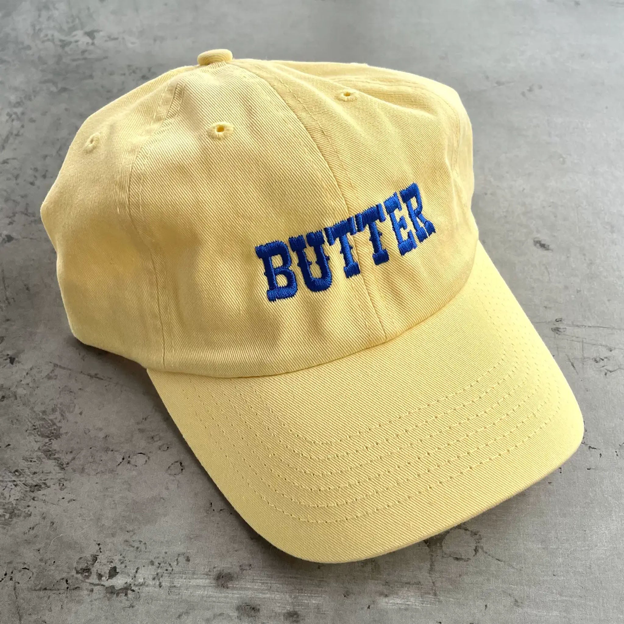 Yellow baseball hat with blue embroidered 'Butter'