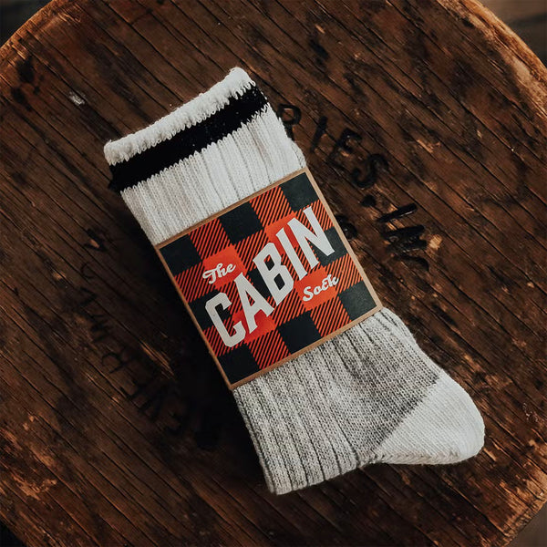 Grey and white recycled wool 'cabin socks' on a wood surface